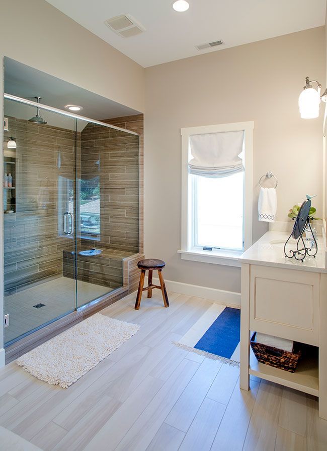 A bathroom with a walk in shower and a window.