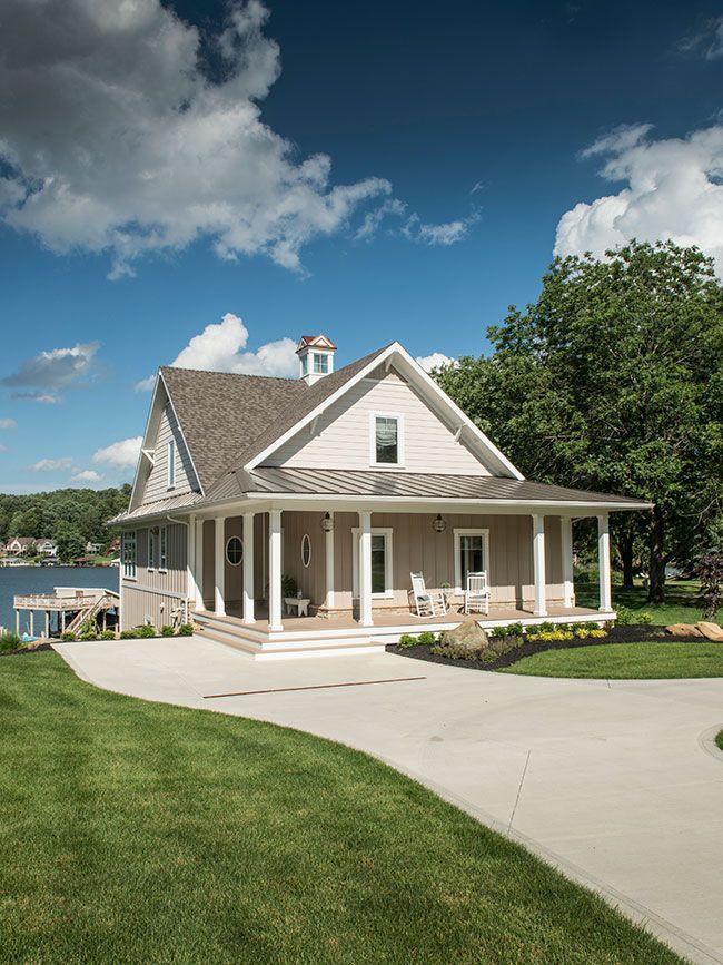 A large house with a large porch and a driveway leading to it.