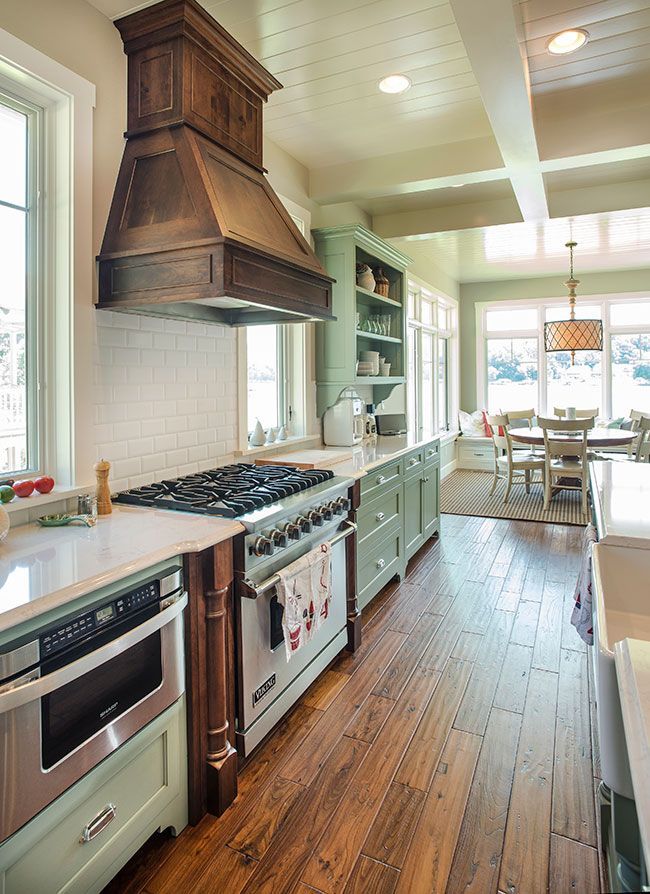 A kitchen with stainless steel appliances and wooden floors.