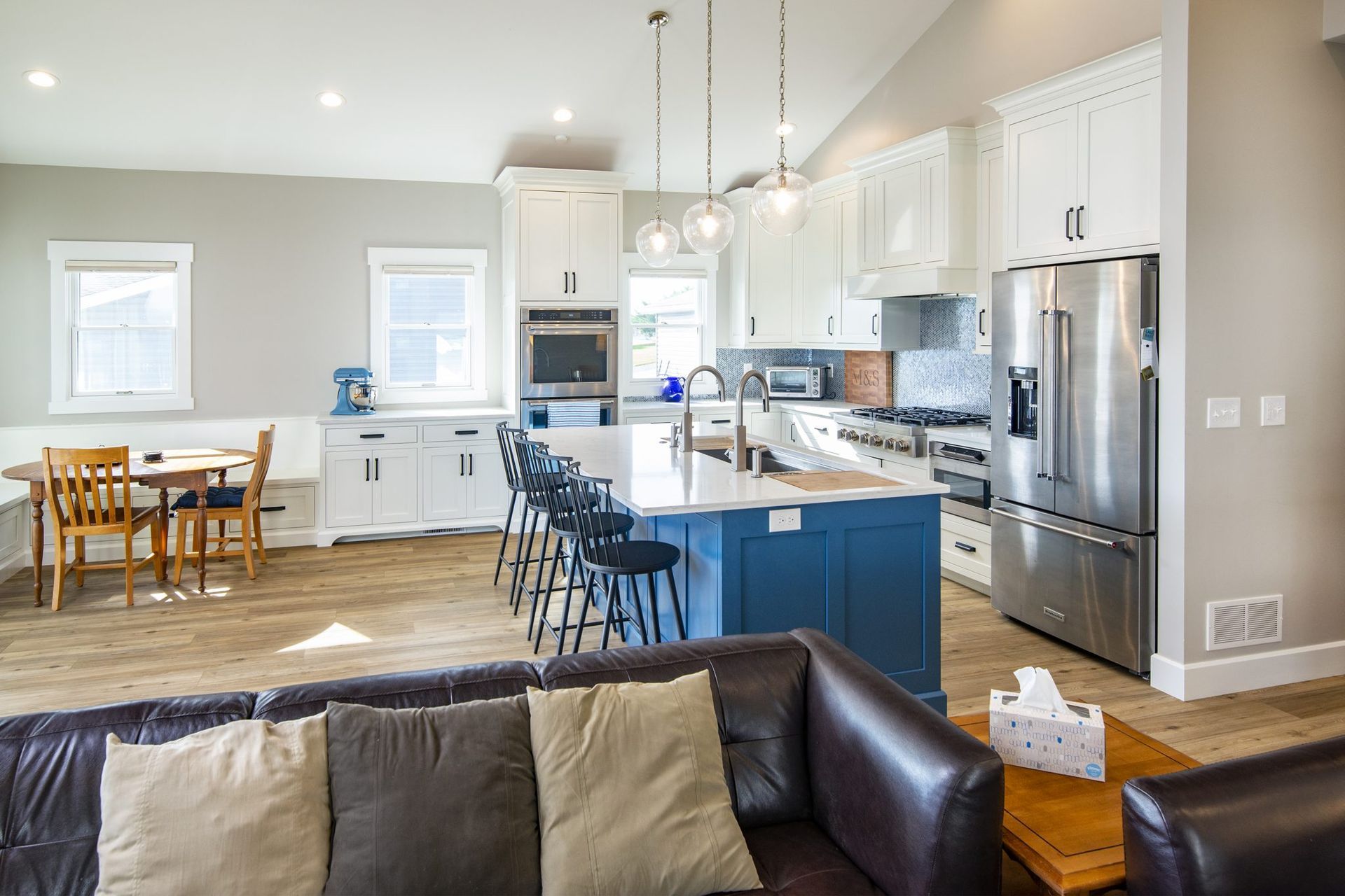 A living room with a couch and a kitchen in the background.