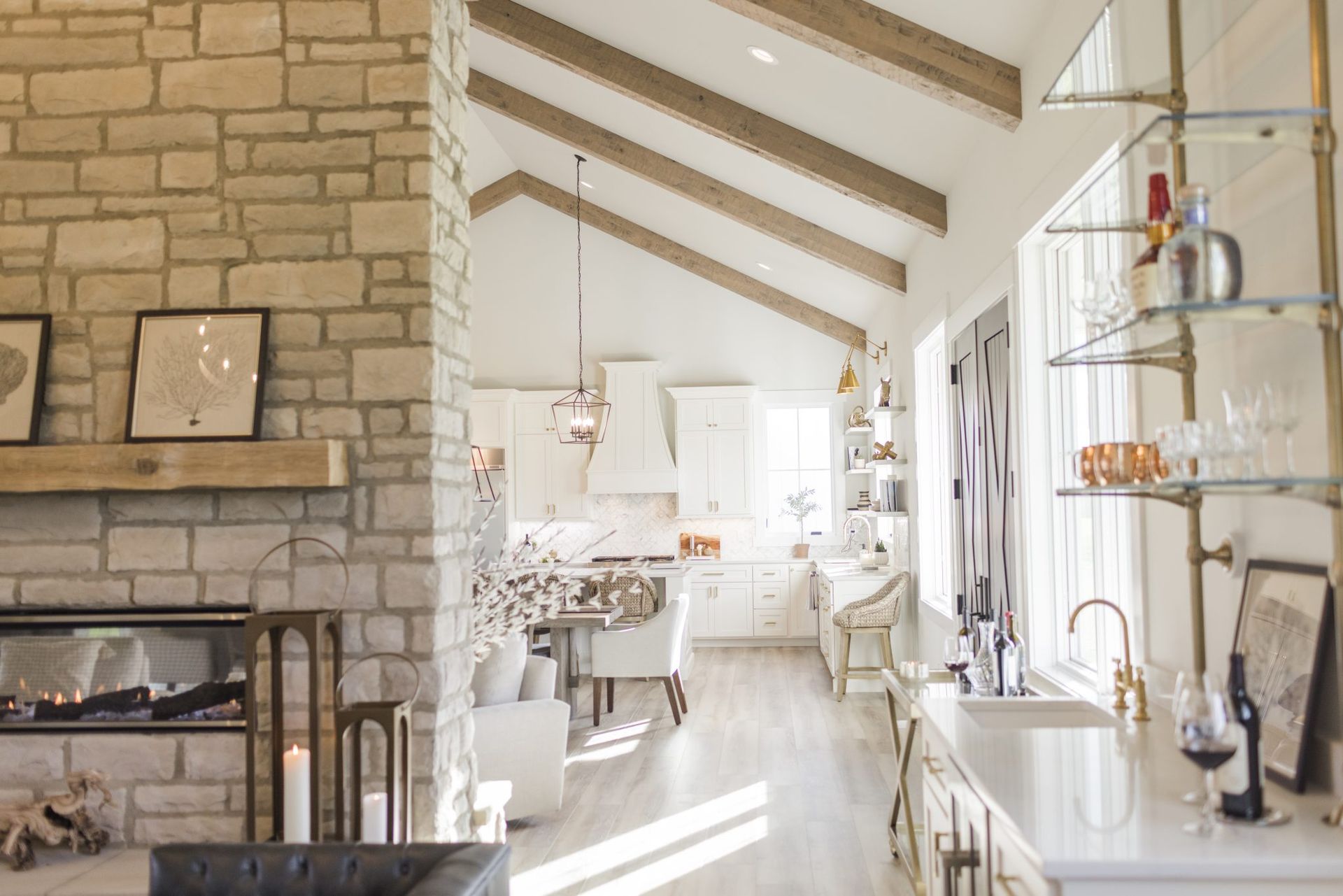 A living room with a fireplace and a kitchen with a vaulted ceiling.