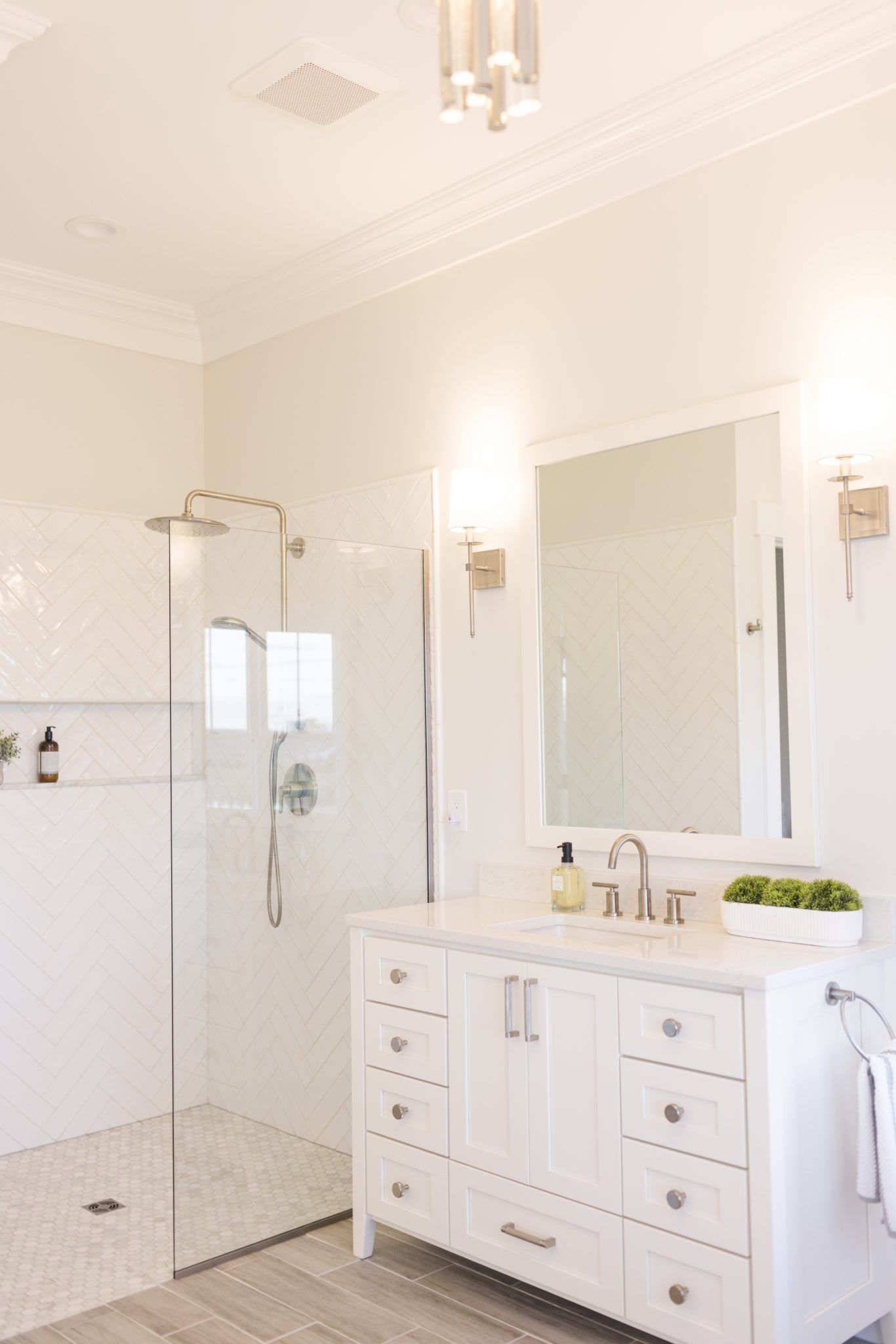 A bathroom with a sink, mirror, and walk in shower.