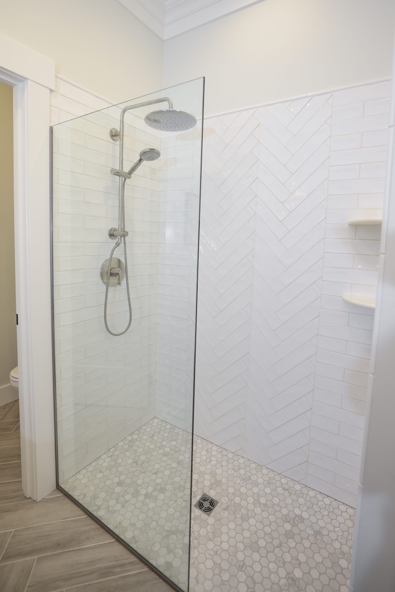A walk in shower with a glass door and a shower head.