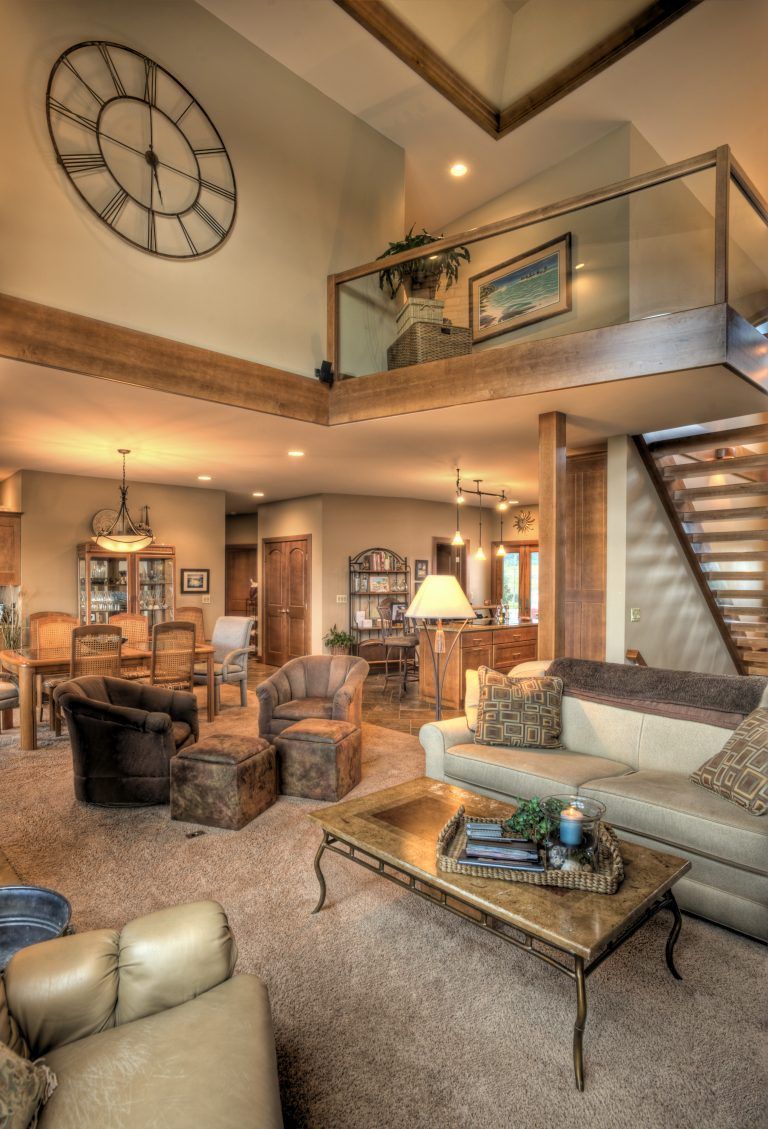 A living room with a clock on the wall above the couch.
