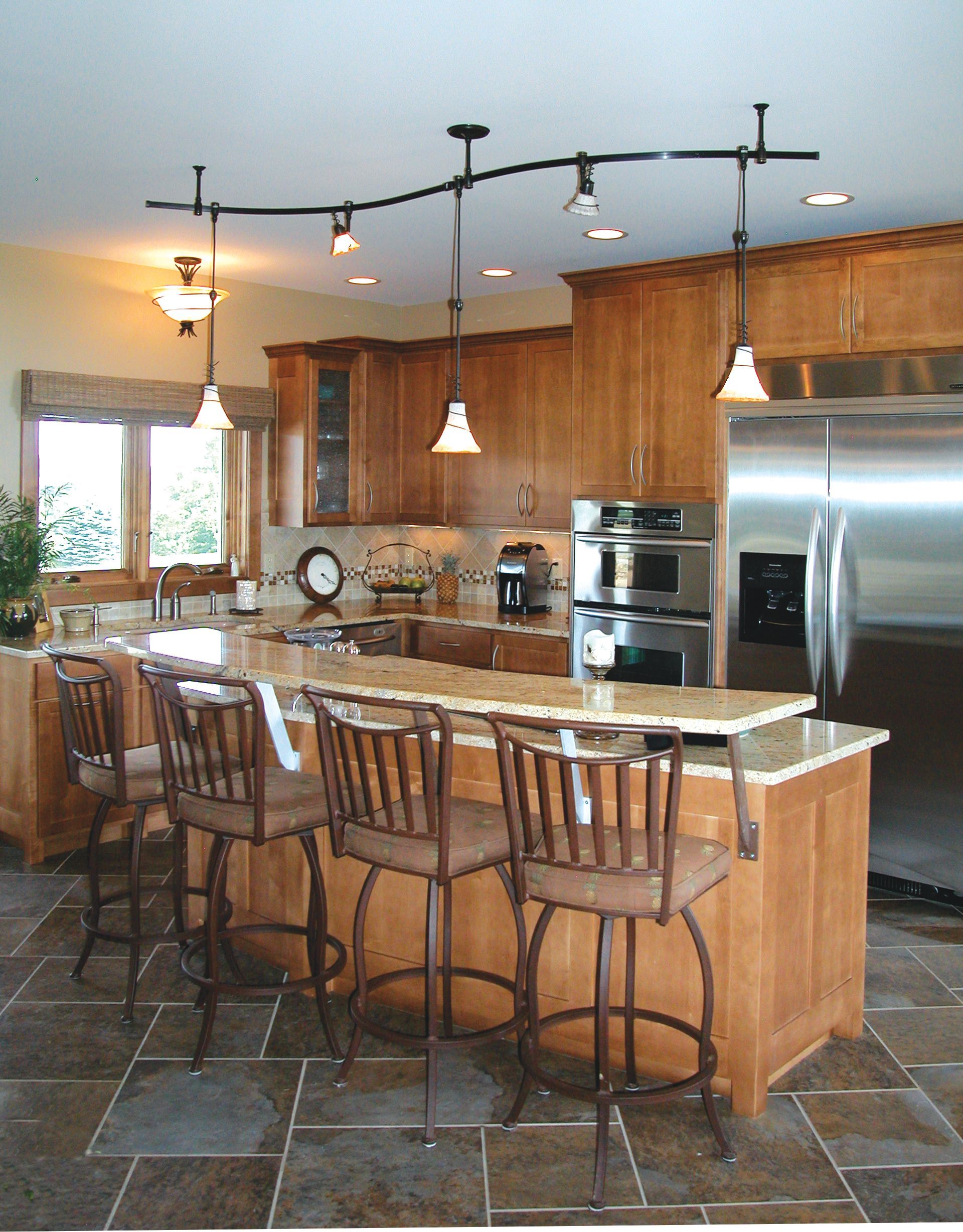 A kitchen with stainless steel appliances and wooden cabinets.