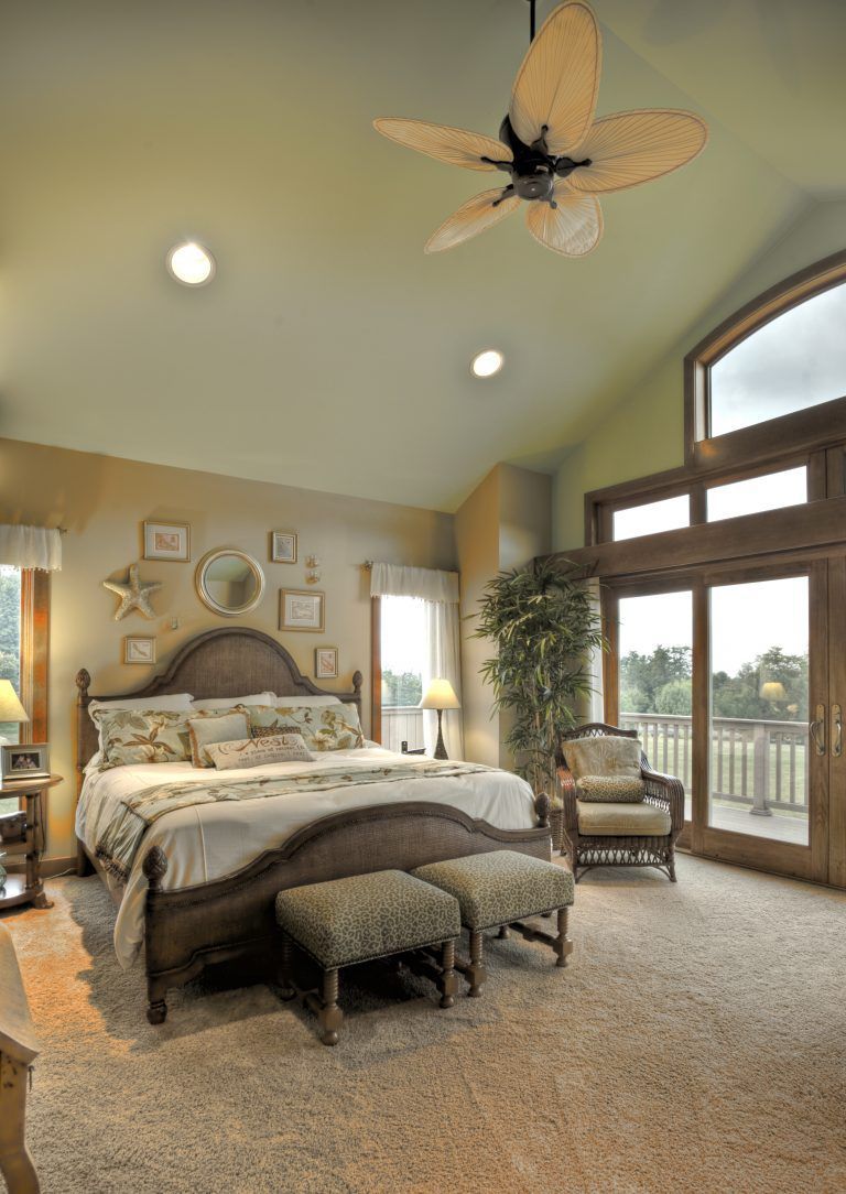 A bedroom with a large bed and a ceiling fan.
