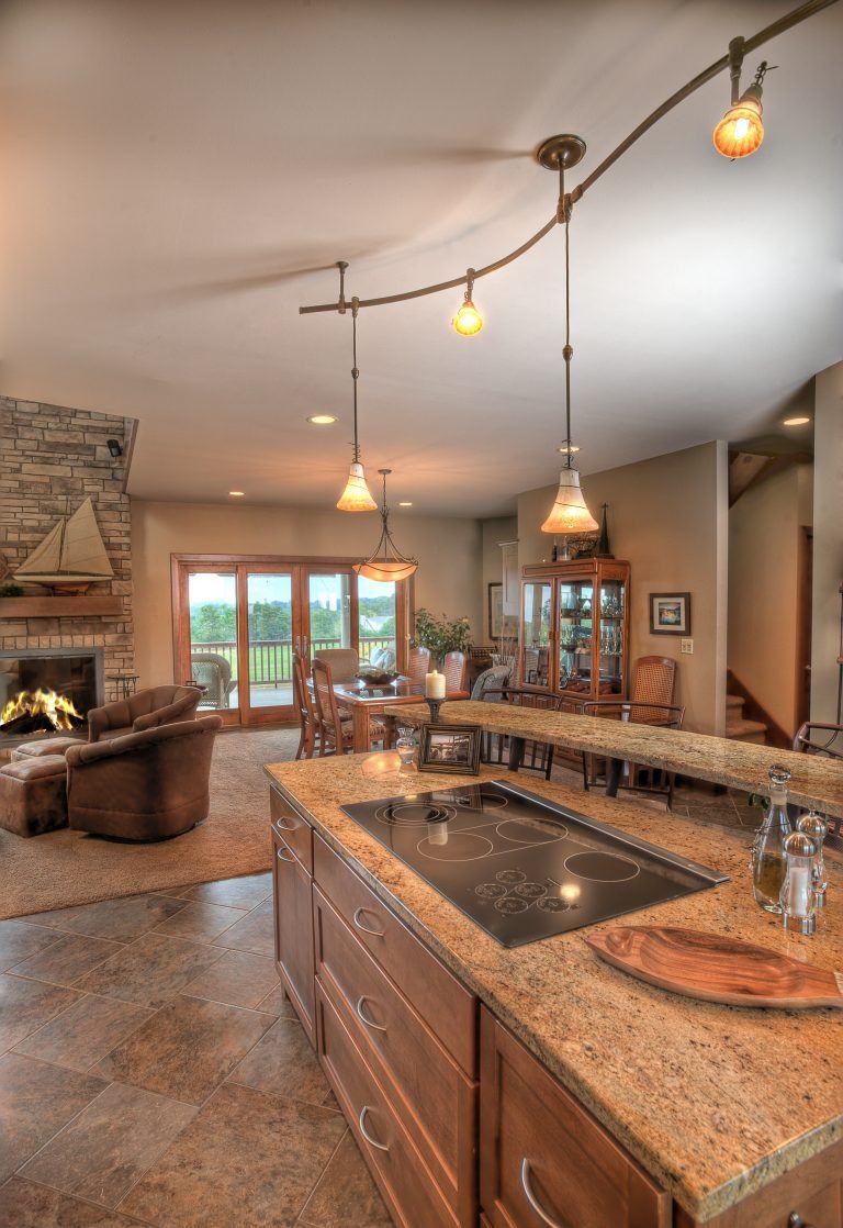 A kitchen with a stove top oven and granite counter tops.