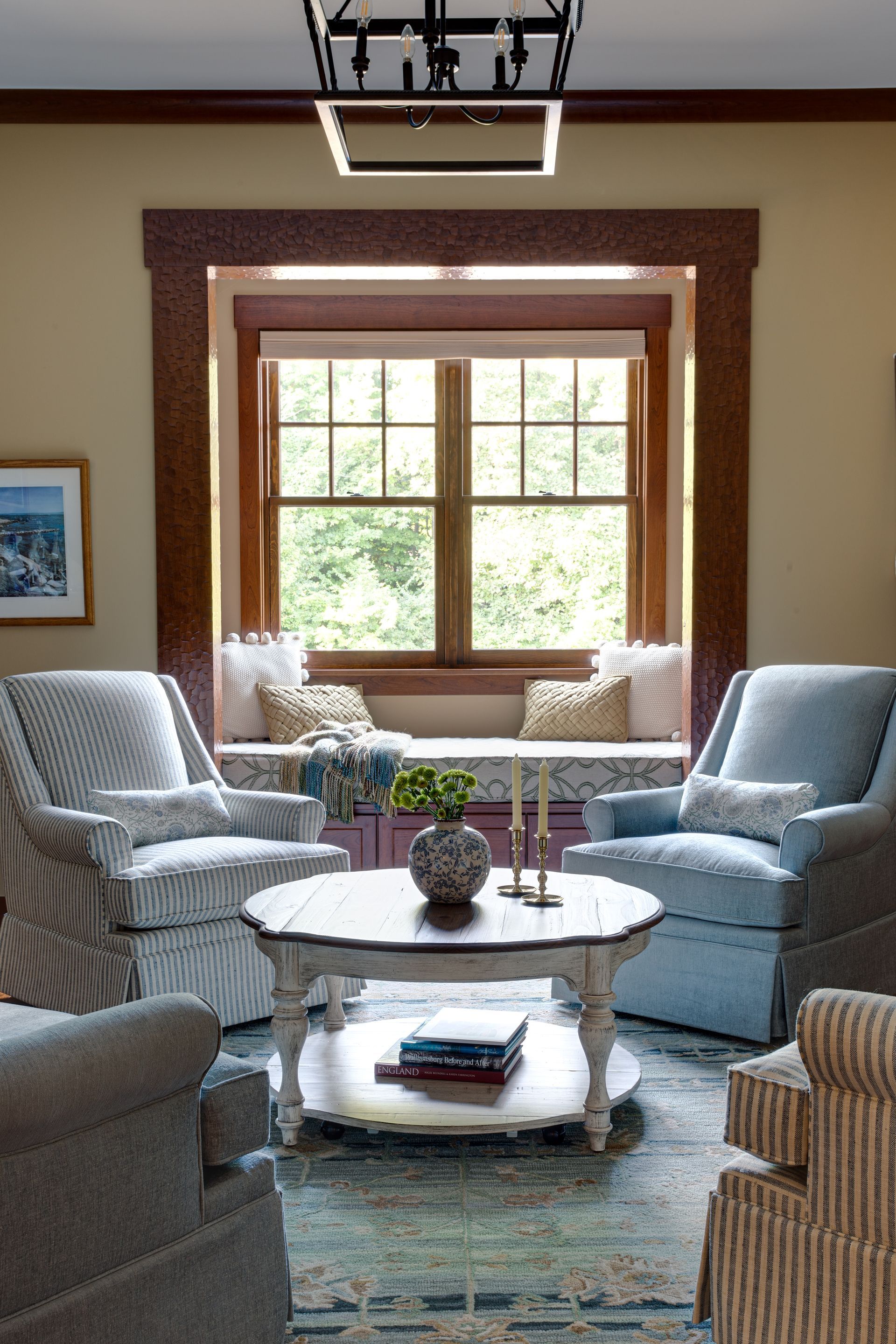 A living room with chairs and a coffee table in front of a window.