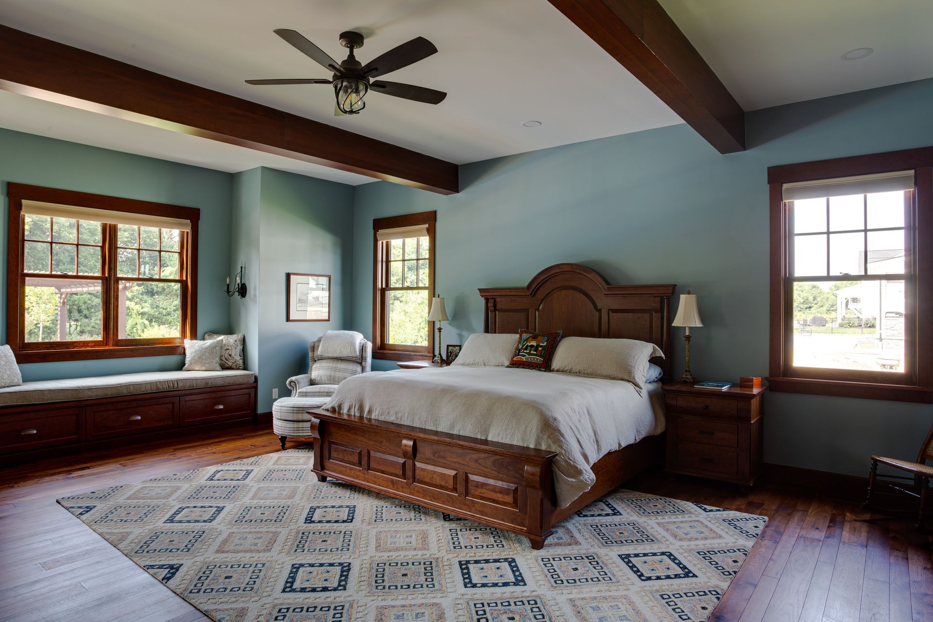 A bedroom with a large bed and a ceiling fan.