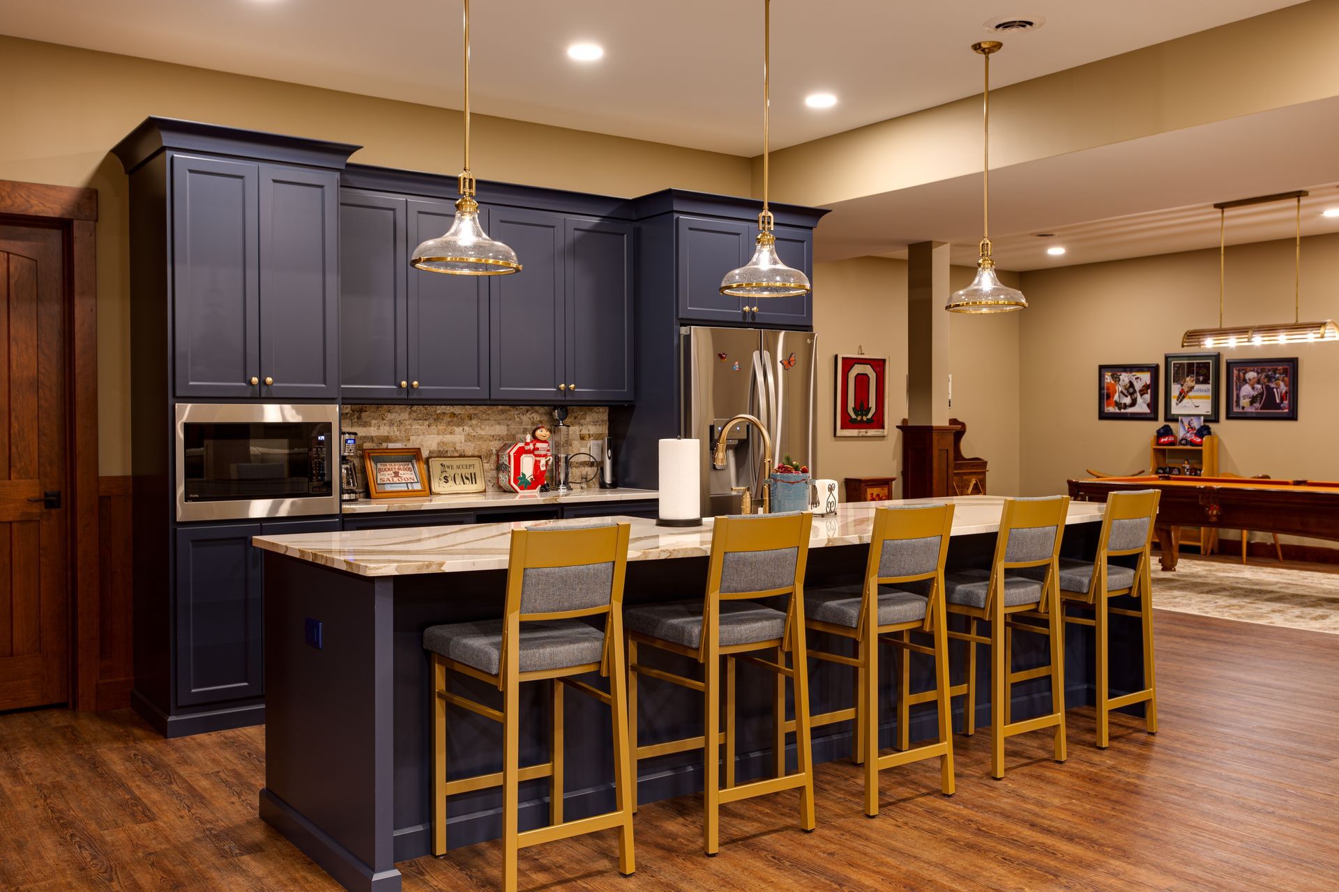 A beautiful custom kitchen with blue cabinets and a large island with stools.