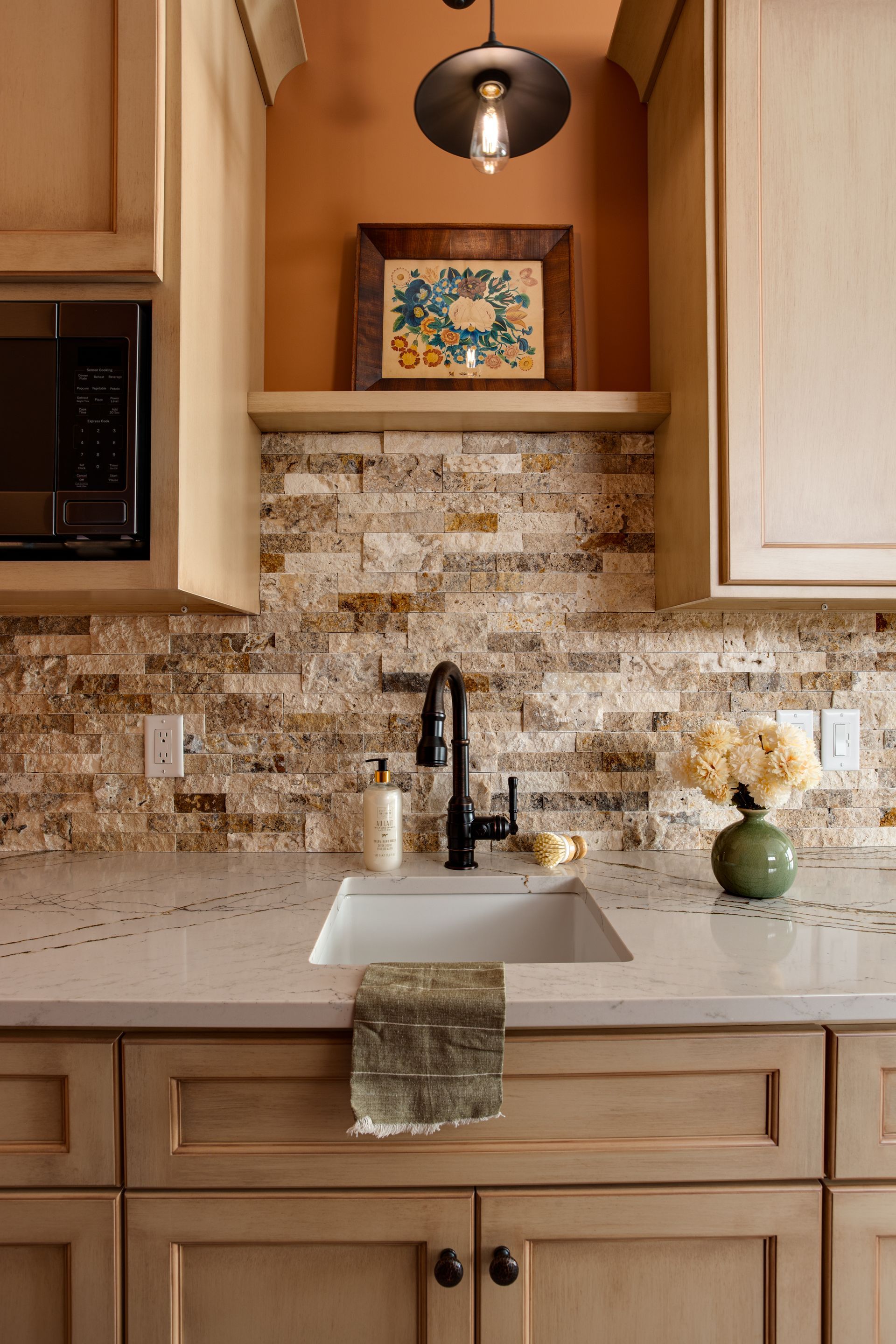 A kitchen with a sink and a picture on the wall.