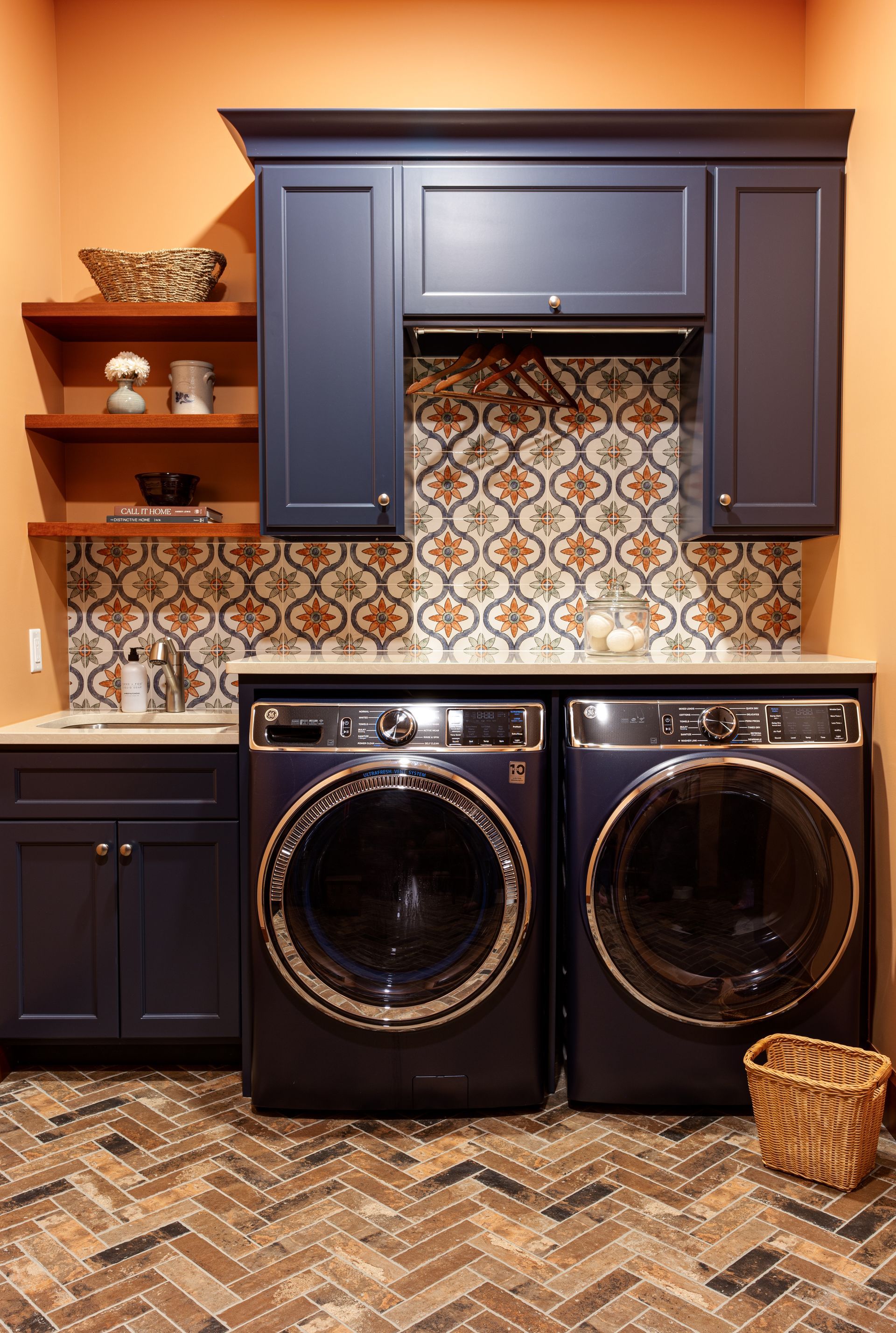 A laundry room with a washer and dryer and blue cabinets.