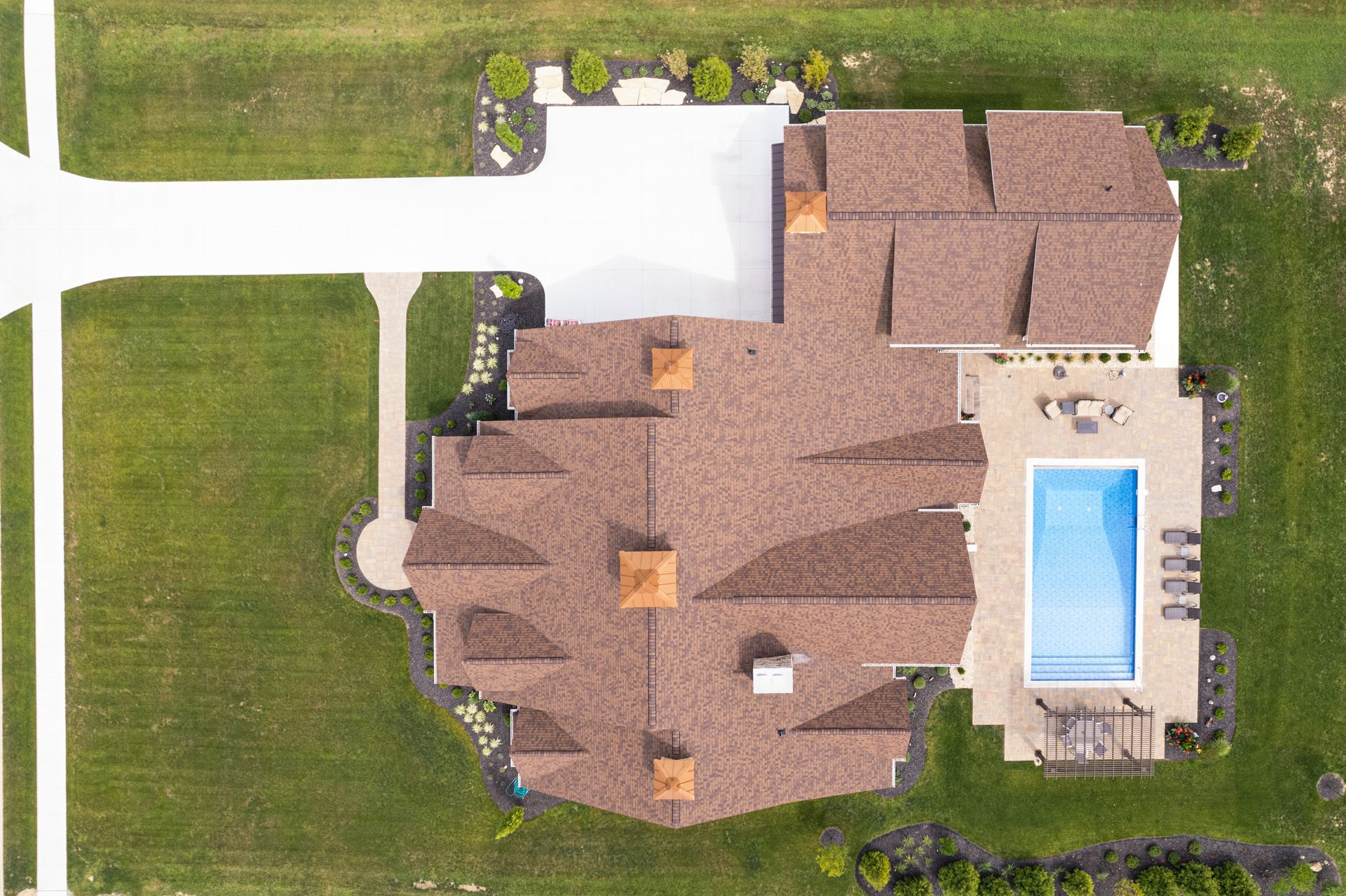 An aerial view of a large house with a pool in the backyard.