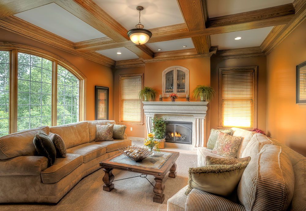 A living room with a couch , chair , coffee table and fireplace.