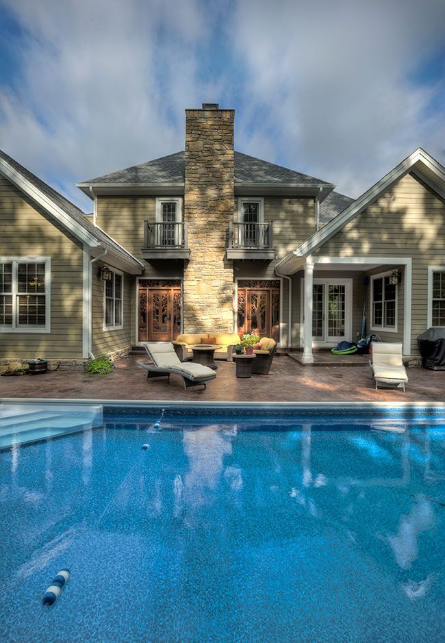A large house with a swimming pool in front of it.