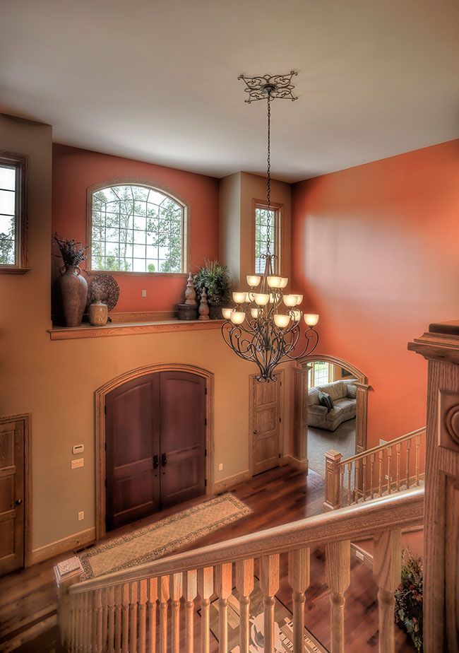 A staircase in a house with a chandelier hanging from the ceiling.