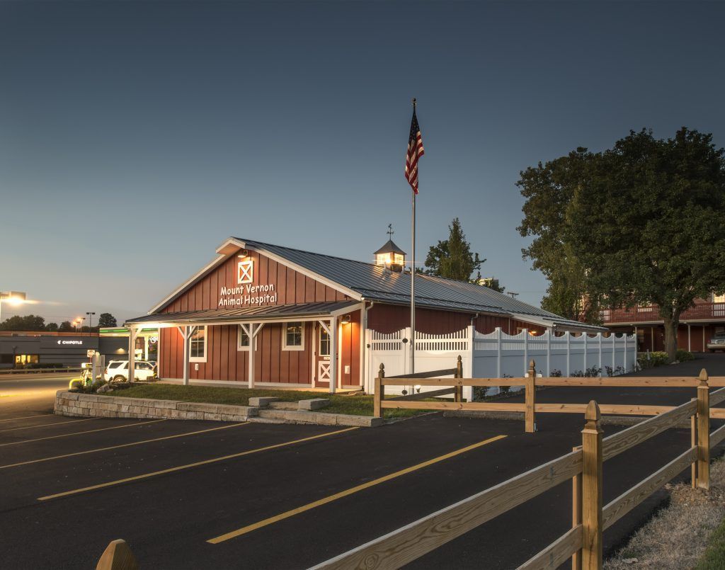 A red barn with an american flag in front of it