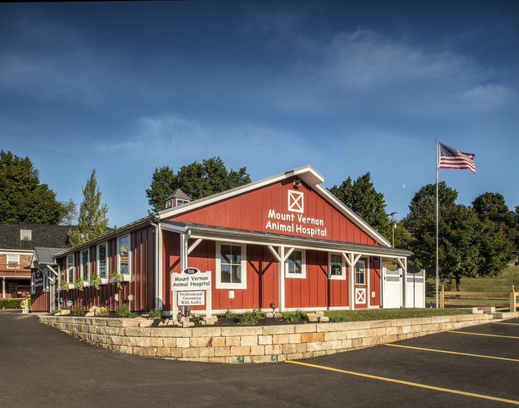 A large red barn with an american flag in front of it