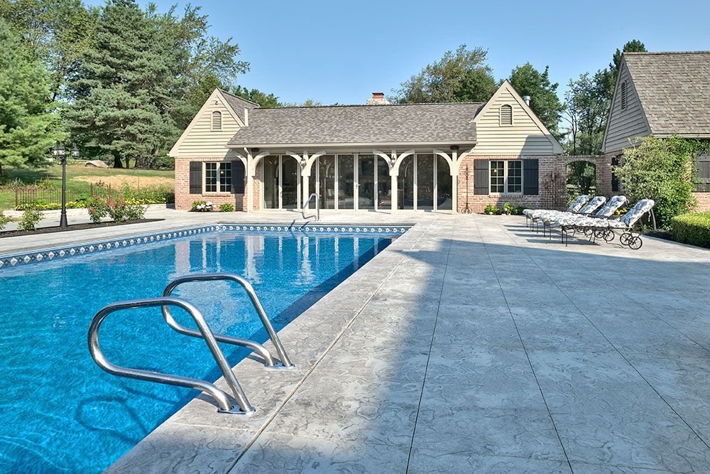 A large house with a swimming pool in front of it.