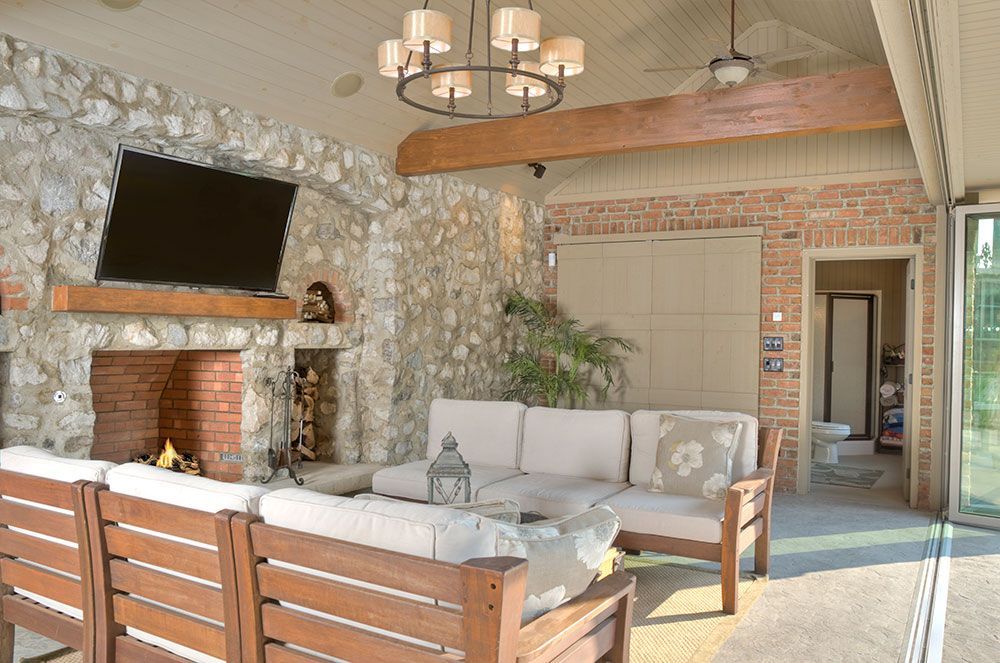 A living room with a couch, chairs, a fireplace, and a flat screen tv.