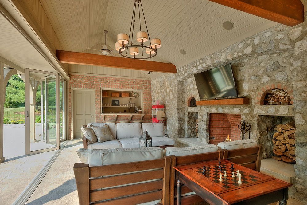 The room of a pool house a fireplace and a chess board.