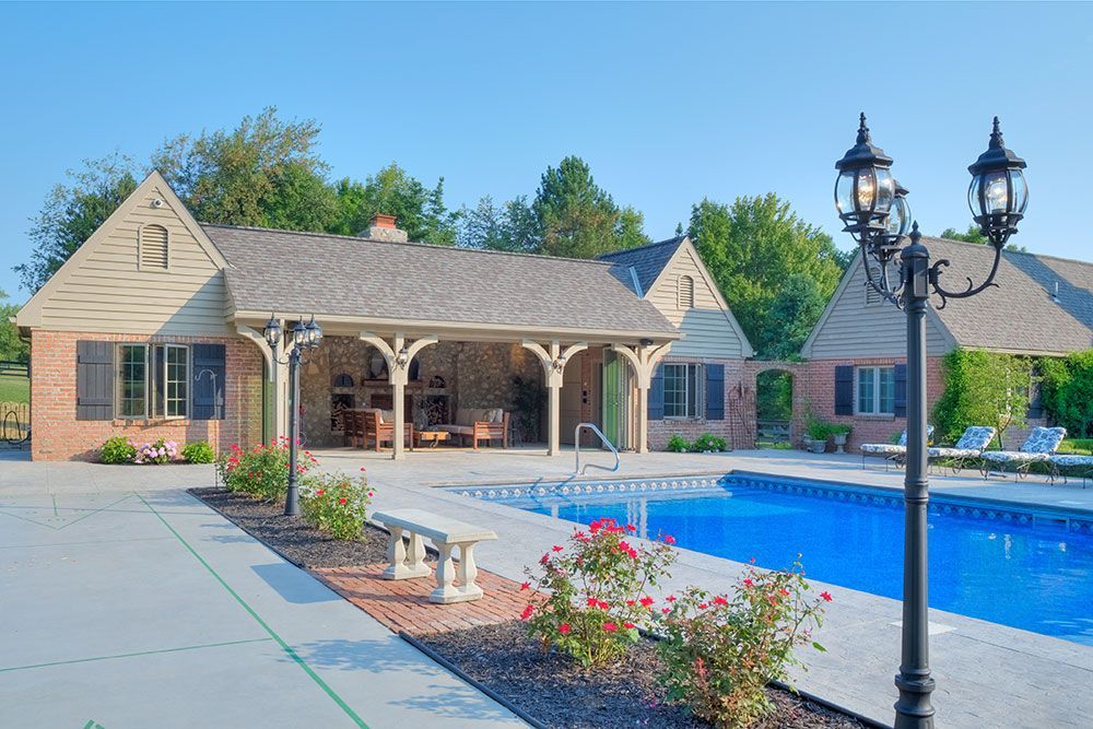 A large house with a swimming pool in front of it. 