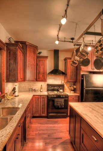A kitchen with a stove a sink and a refrigerator.