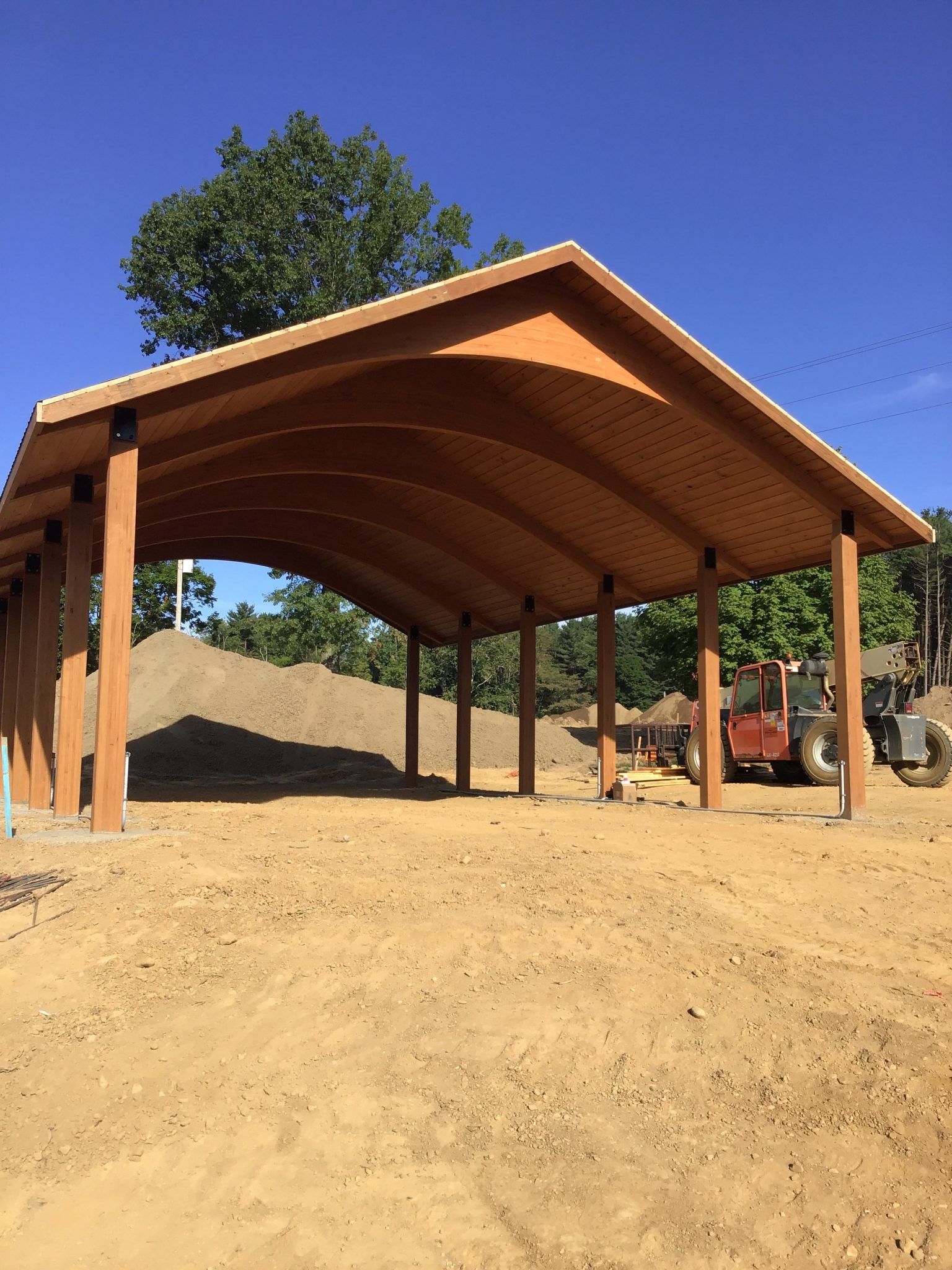 A large wooden structure in the middle of a dirt field.