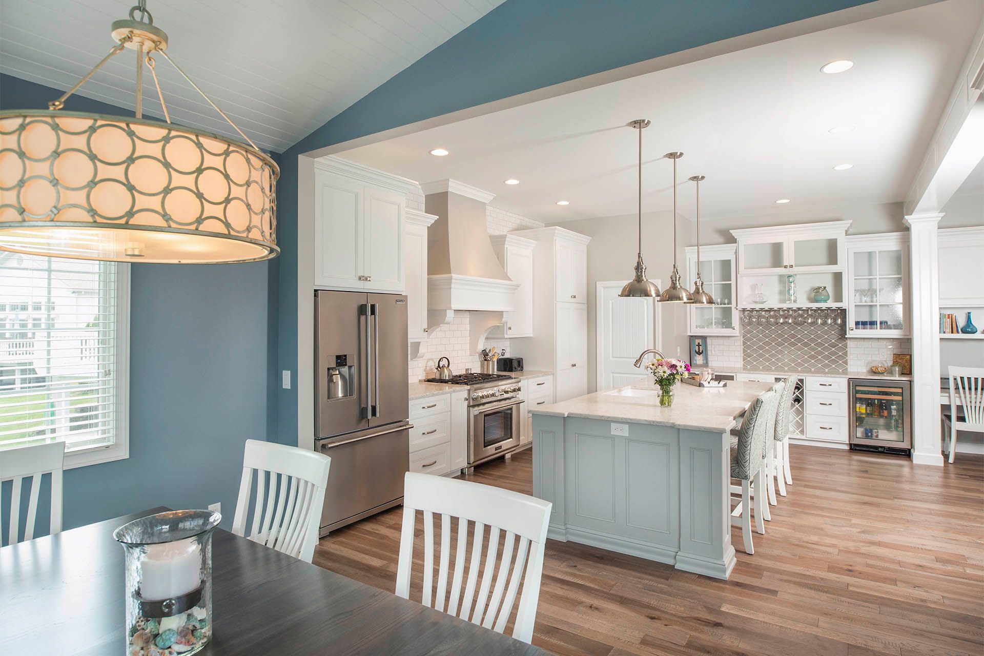 A kitchen and dining room in a house with a large island in the middle.