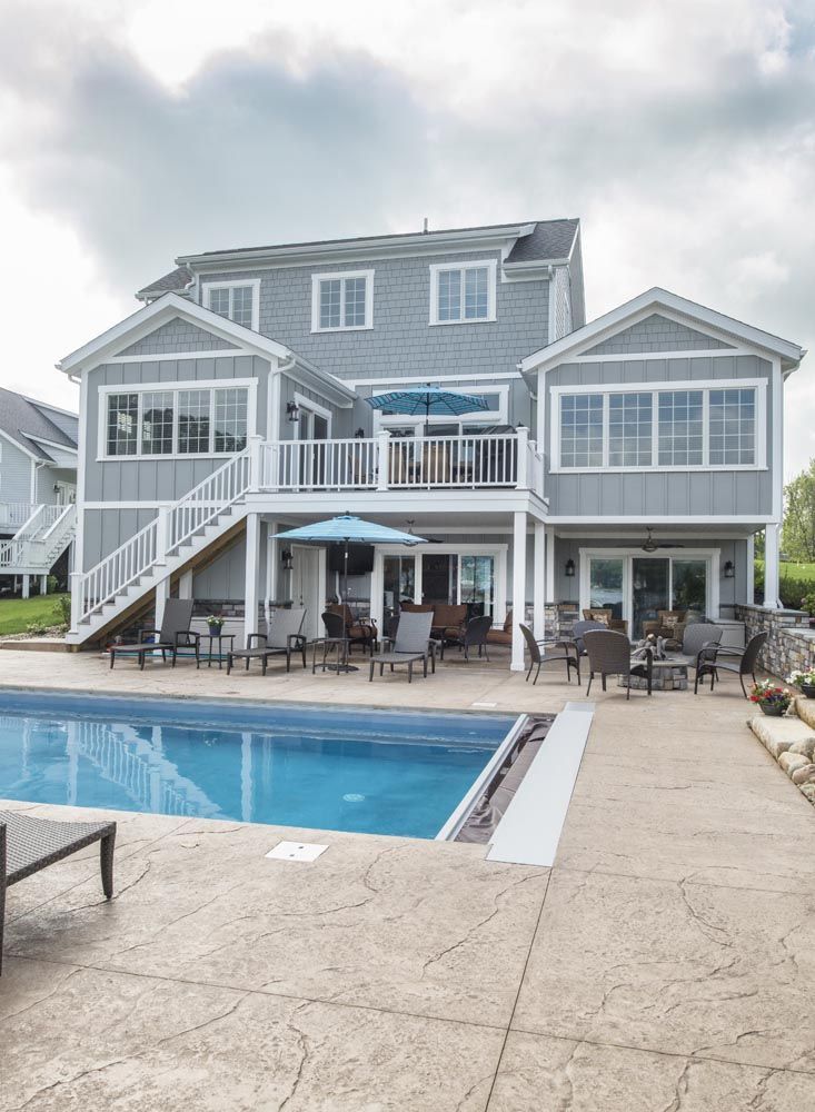 A large house with a large swimming pool in front of it.