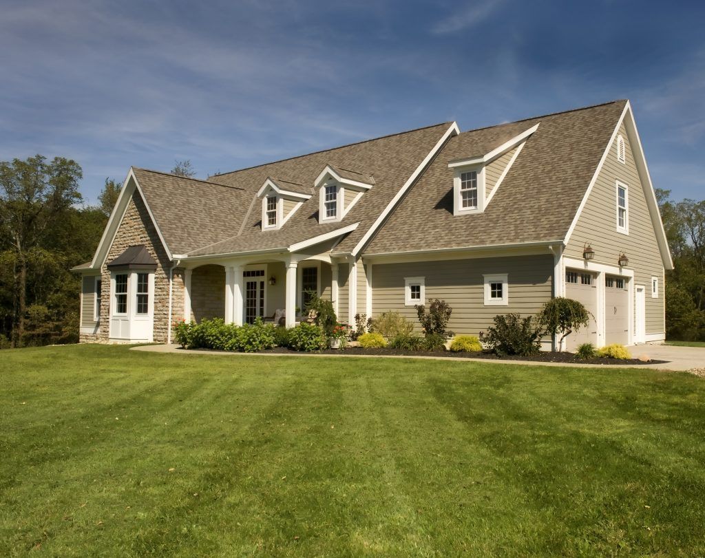 A large house with a lush green lawn in front of it