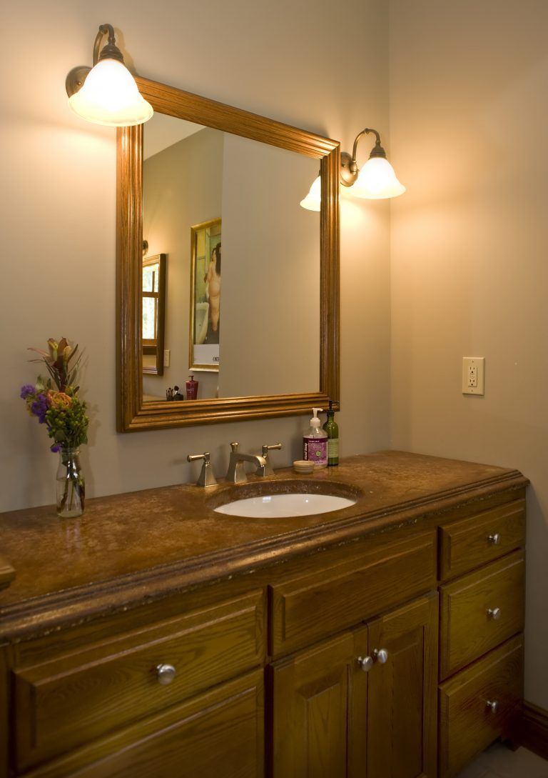 A bathroom with a sink and a large mirror.