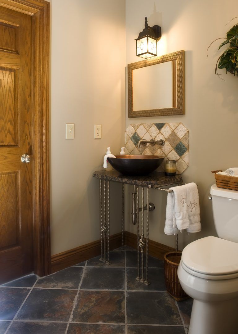 A bathroom with a toilet a sink and a mirror.