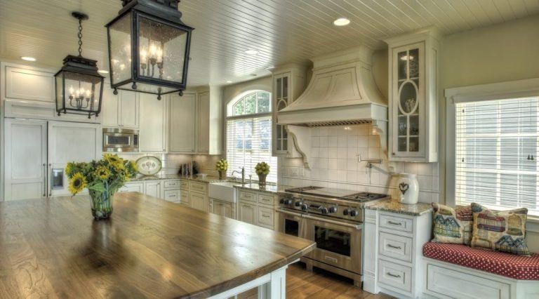 A kitchen with a large island and a stove top oven.