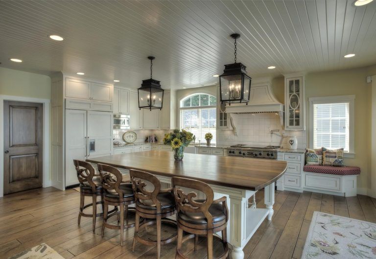 A kitchen with a large island and stools.