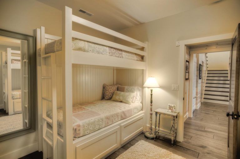 A bedroom with a bunk bed and a mirror.
