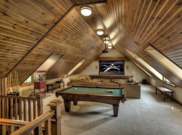 An attic with a pool table and a flat screen tv
