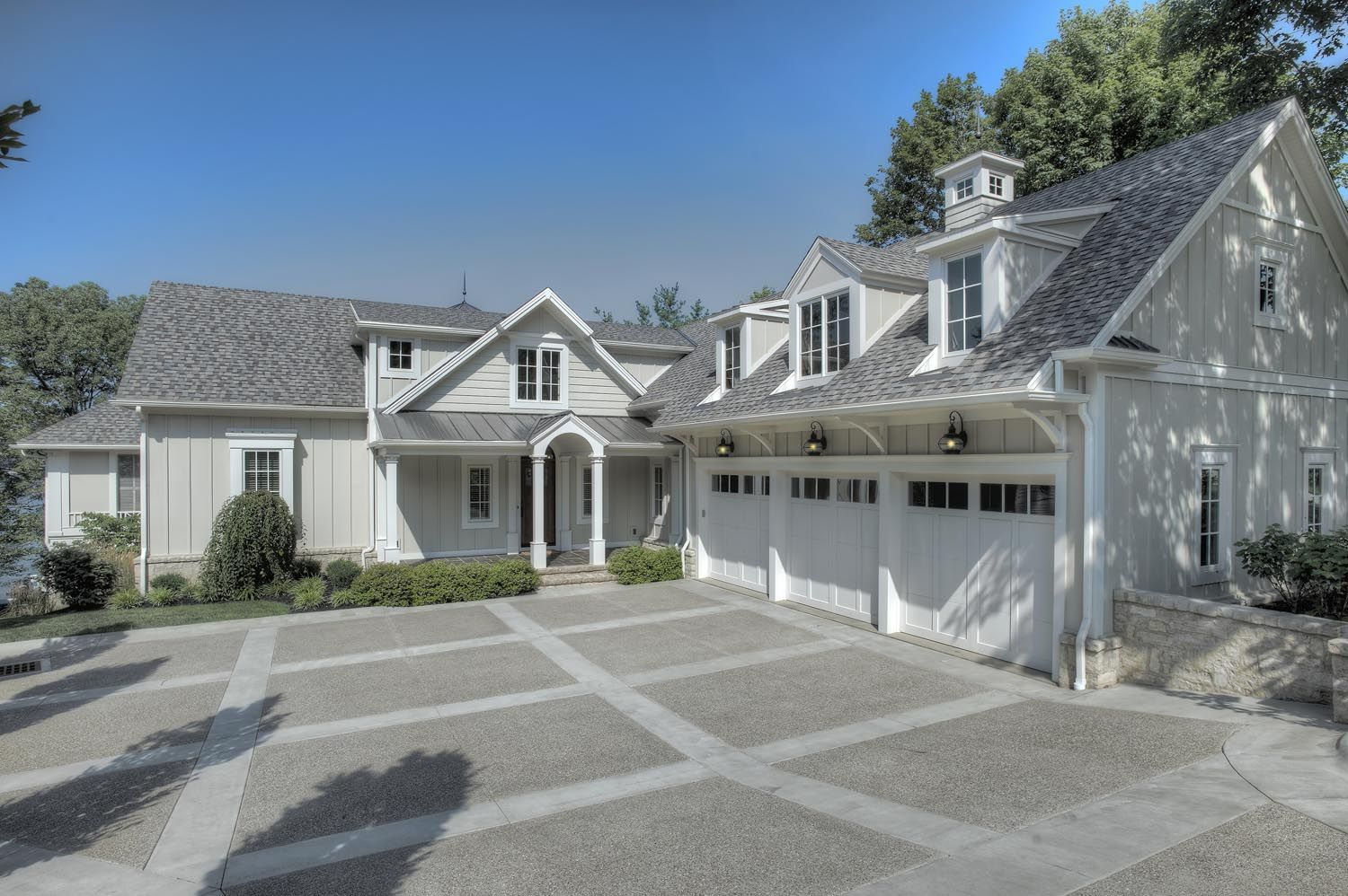 A large white house with a driveway leading to it.