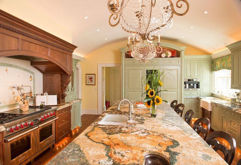A kitchen with a large island and a chandelier hanging from the ceiling.
