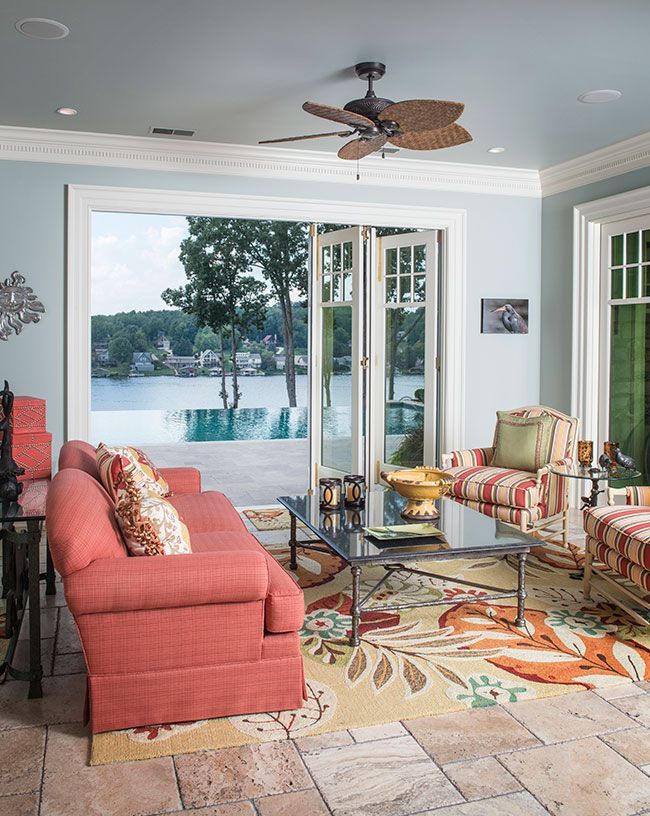A living room with a red couch and a ceiling fan.