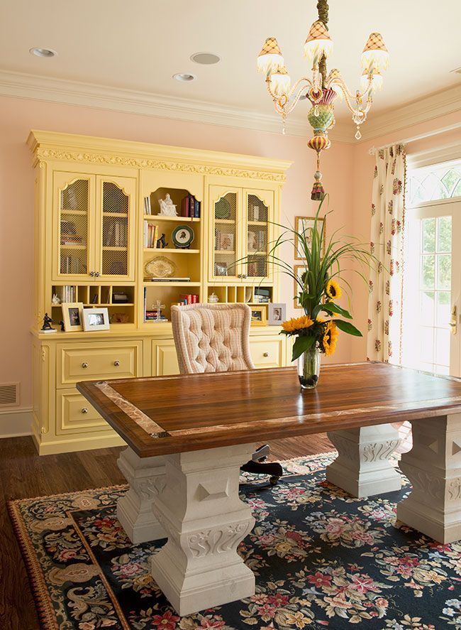 A dining room with a table and chairs and a chandelier hanging from the ceiling.