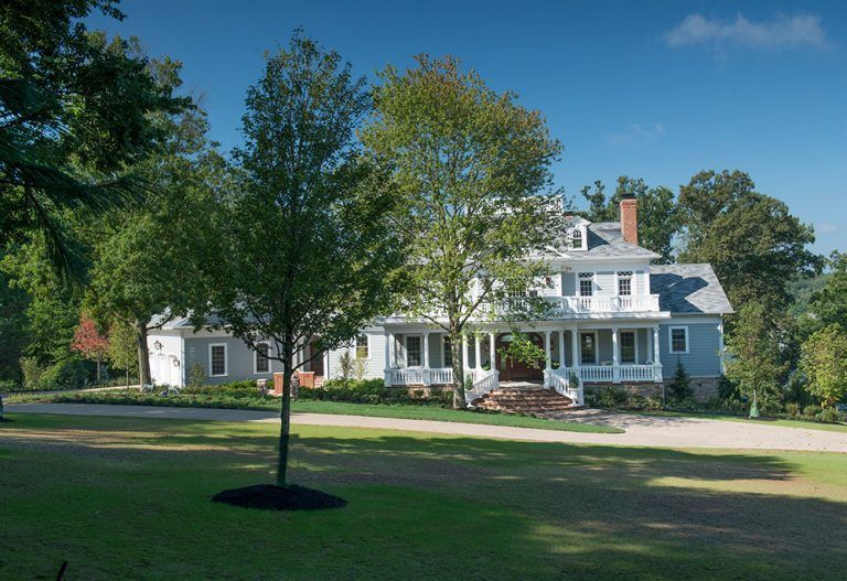 A large white house with a tree in front of it.