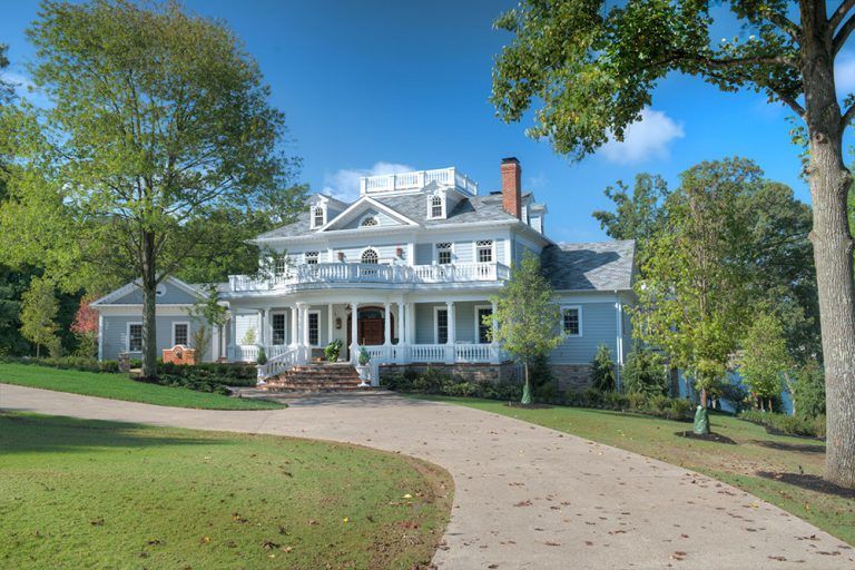 A large white house with a driveway leading to it.