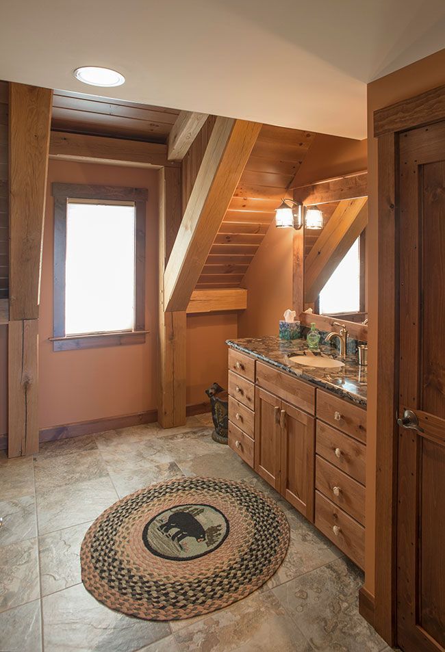 A bathroom with a rug on the floor and a staircase in the background.