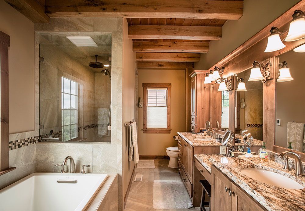 A bathroom with a tub , sinks , and mirrors