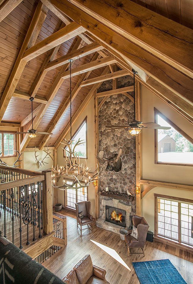 An aerial view of a living room with a fireplace and wooden beams.