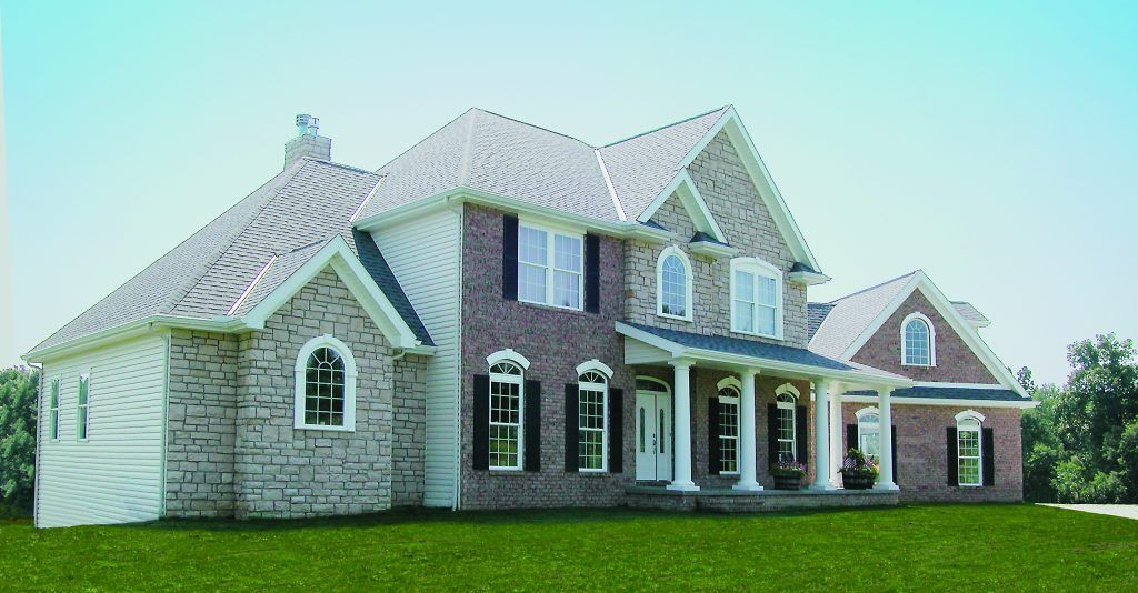 A large brick house with a white trim and shutters