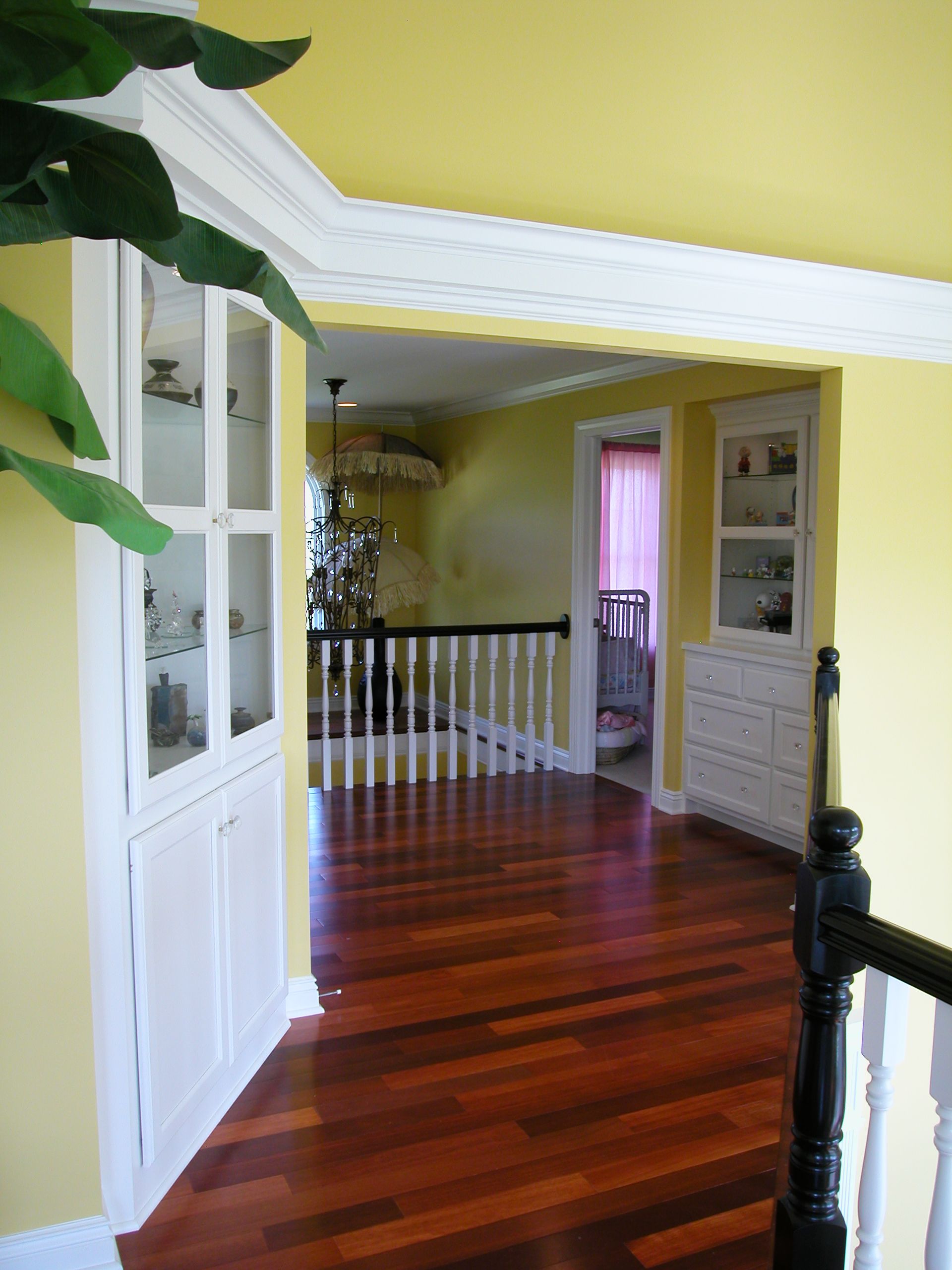 A hallway with hardwood floors and yellow walls