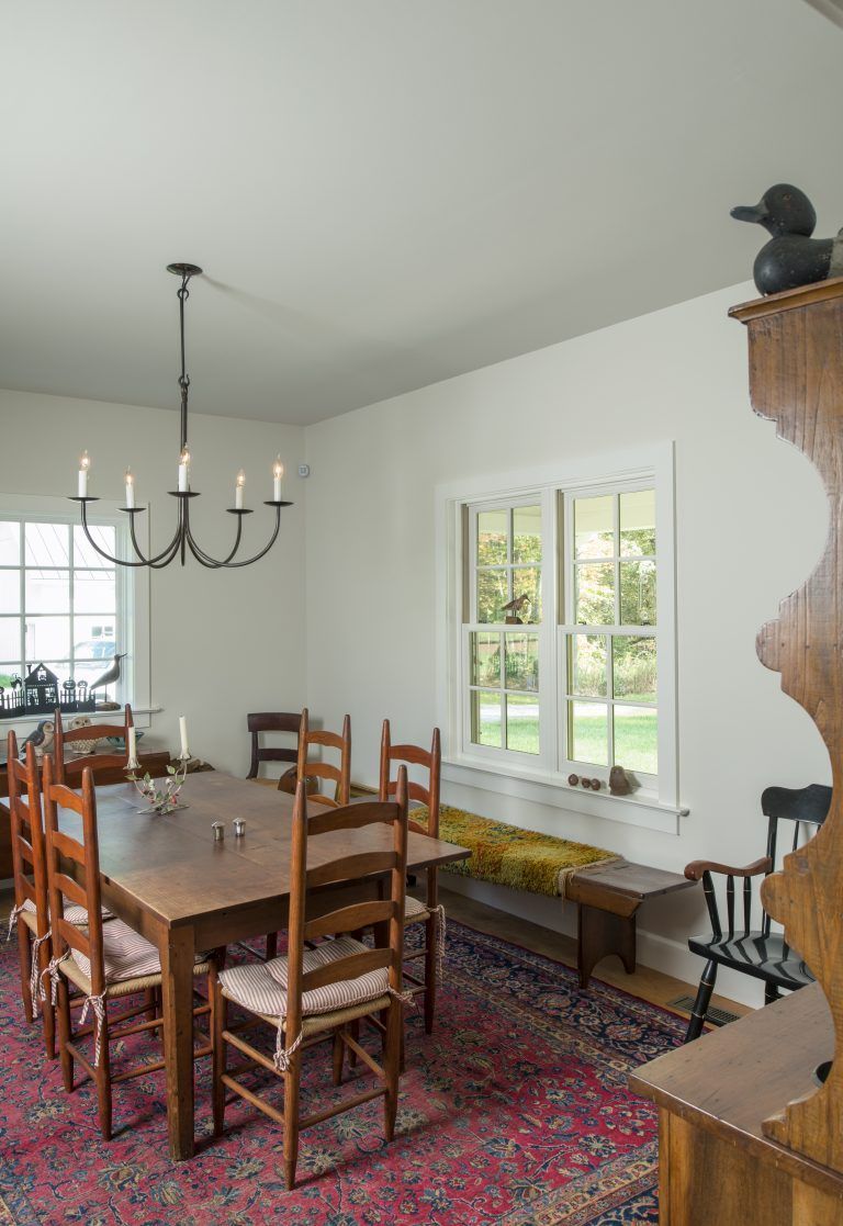 A dining room with a table and chairs and a chandelier hanging from the ceiling.