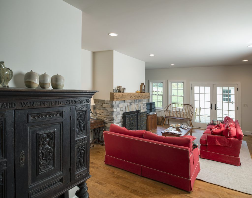 A living room with red furniture and a fireplace.